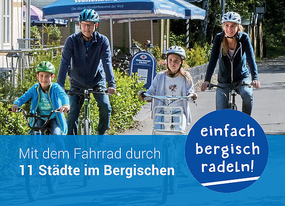 Das Bild zeigt eine Familie mit zwei Kindern auf einem sonnigen Radweg im Bergischen