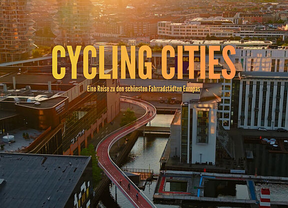 DAs Bild zeigt eine Fahrradbrücke aus der Vogelperspektive im Licht des Sonneuntergabgs